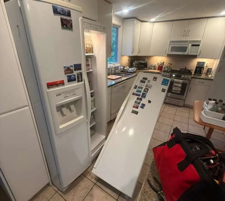 Side-by-side refrigerator door removed for service