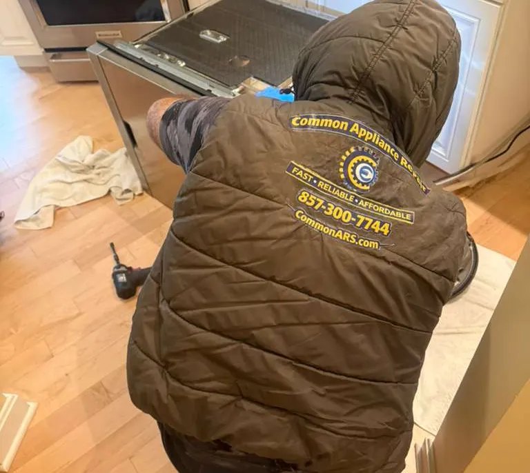 Technician diagnosing a dishwasher during an in-home visit