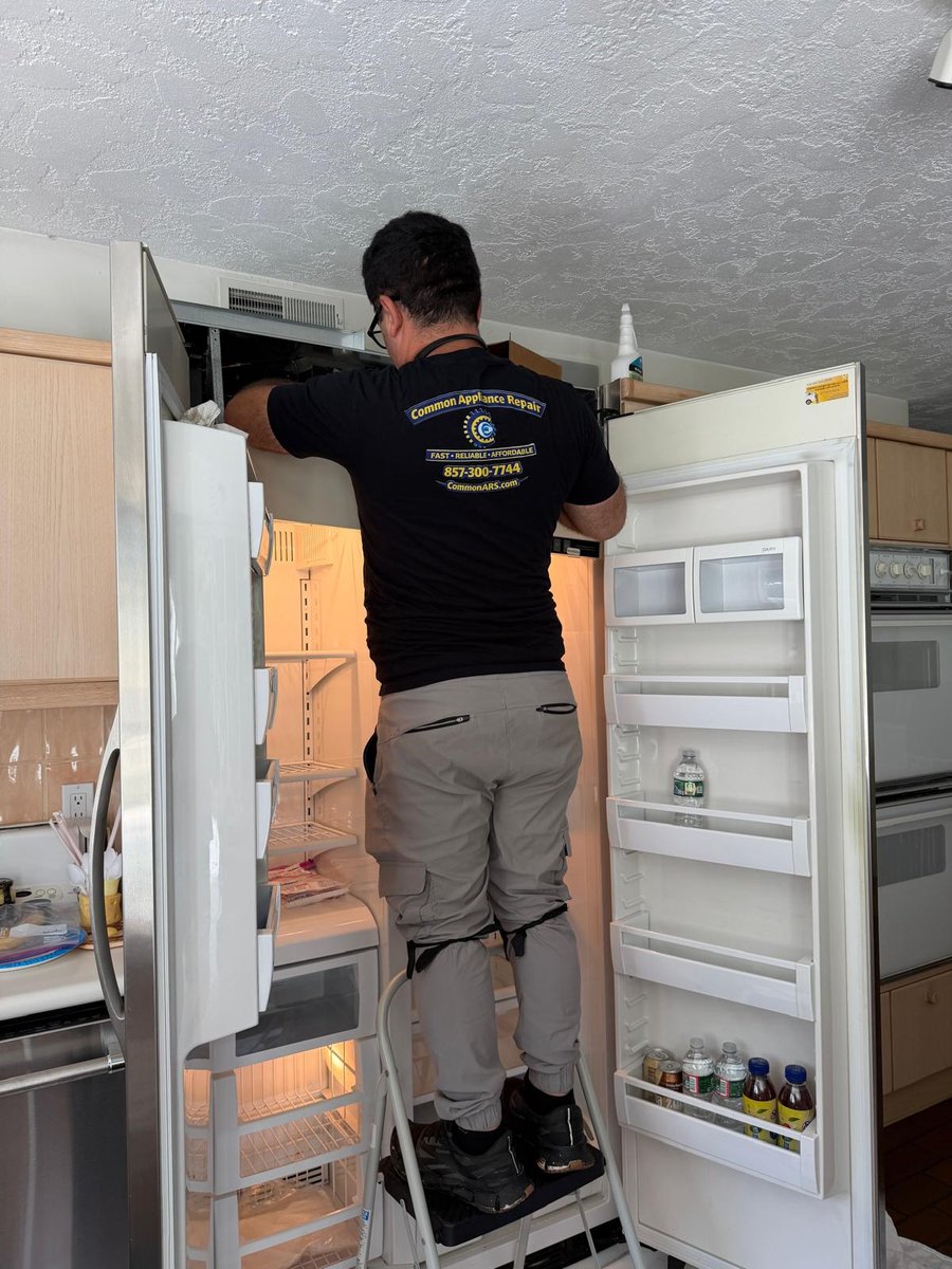Technician servicing a side-by-side refrigerator