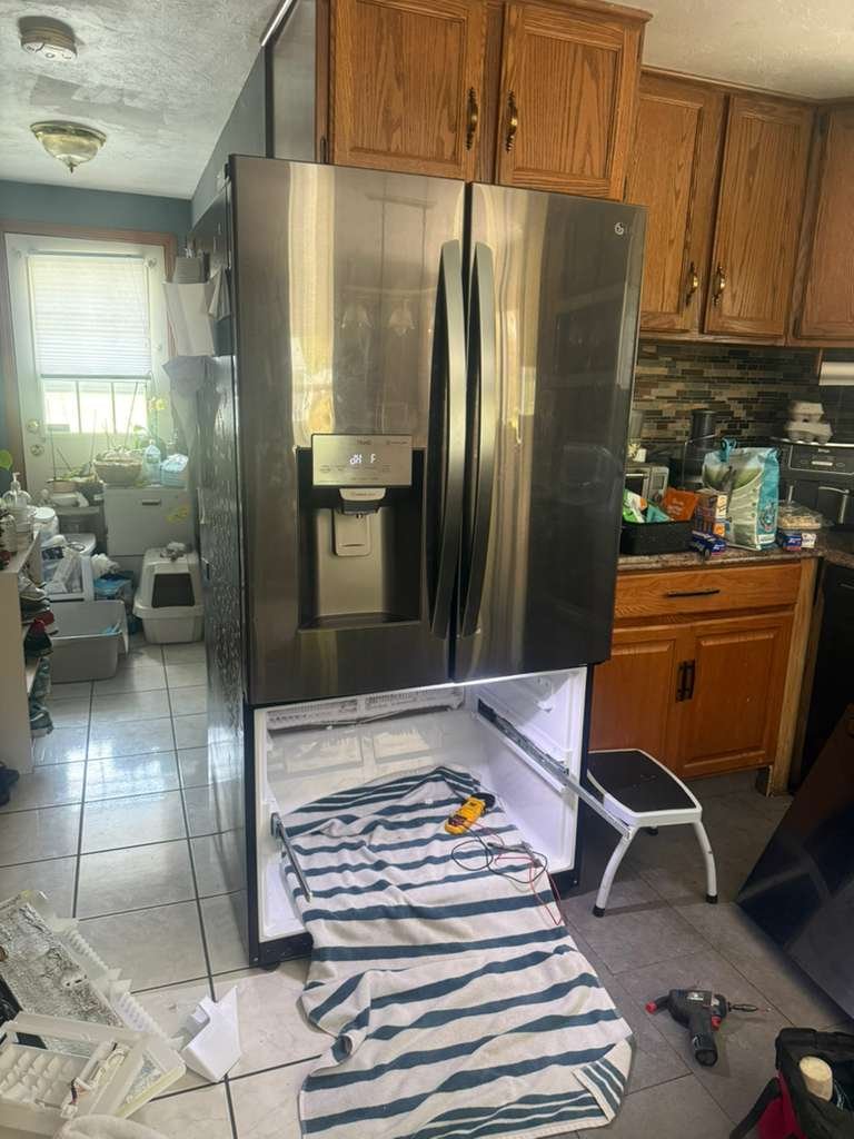 French-door refrigerator pulled out for service